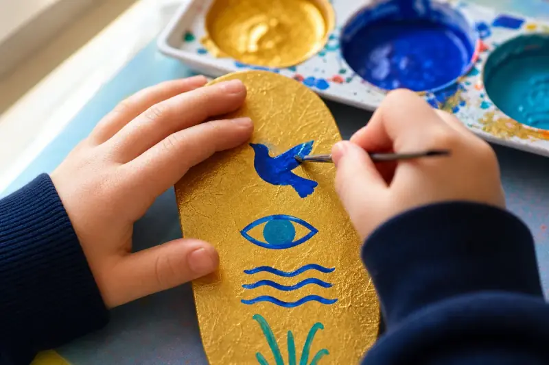 Close view of a finished cartouche, its hieroglyphs painted in several colours and a fine brush outlining the last sign in black.